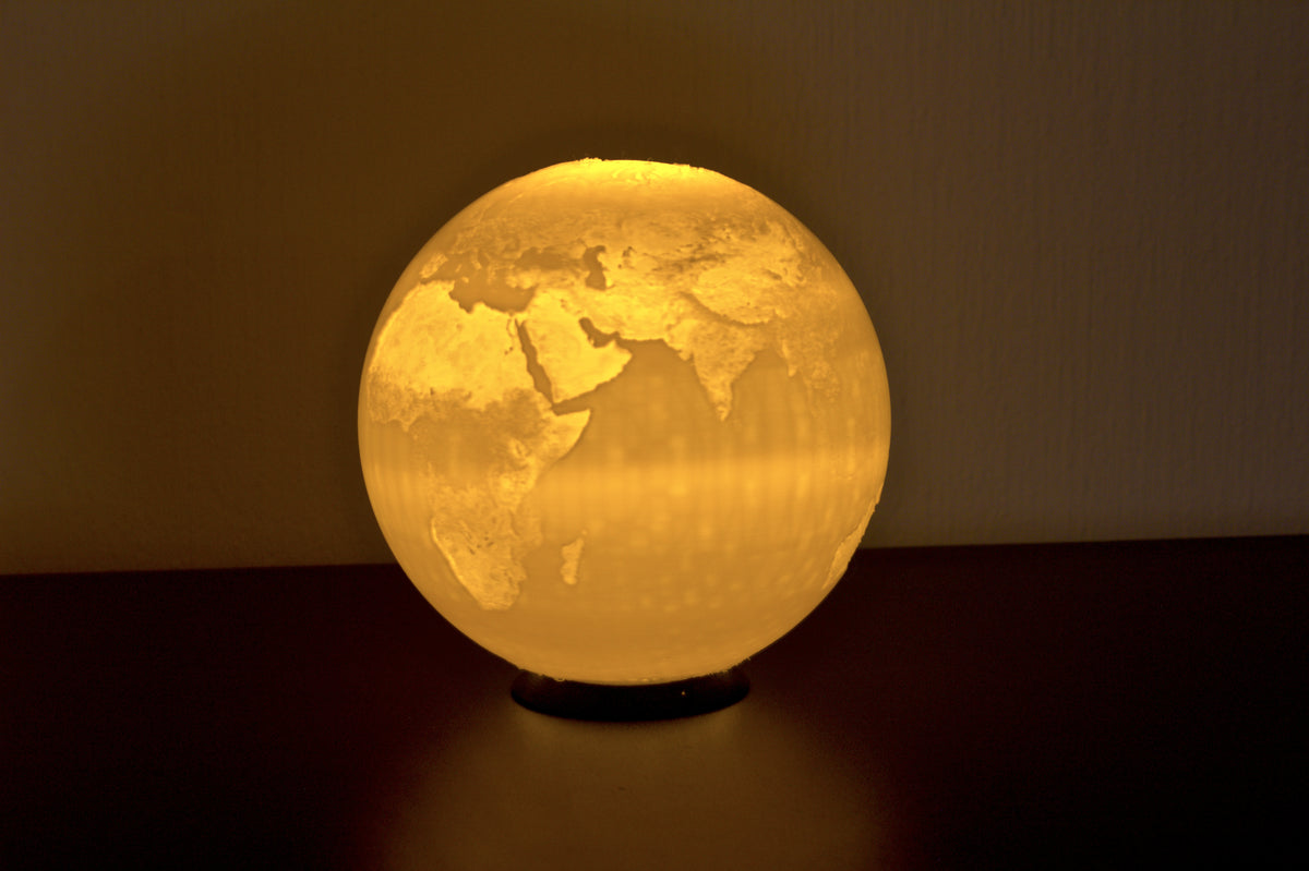 Erdkugel-Lampe als Lithophane-Kugel, von innen mit warmem Licht beleuchtet: Kontinente hell, Ozeane dunkel